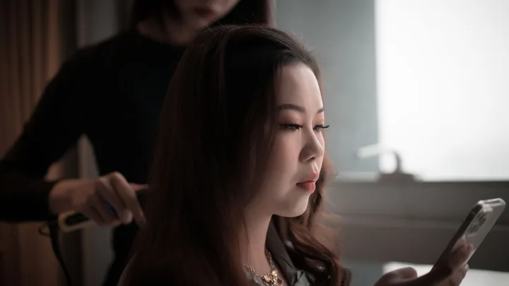 Hair stylist working with an Asian client in a salon