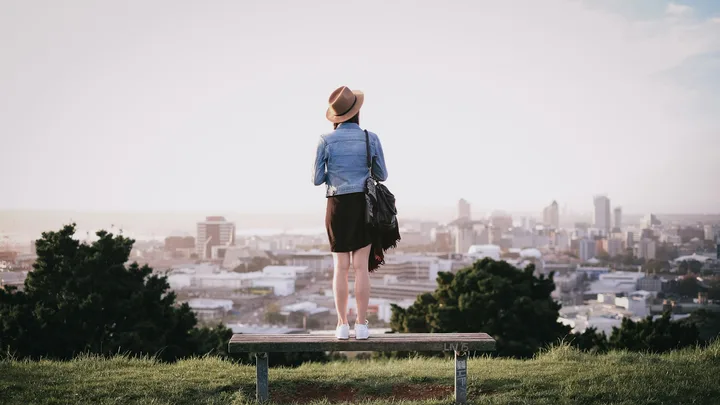 Woman looking over the Auckland skyline from Mount Eden