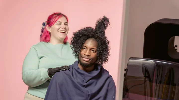 Hair stylist and client smiling during a curly-hair styling session