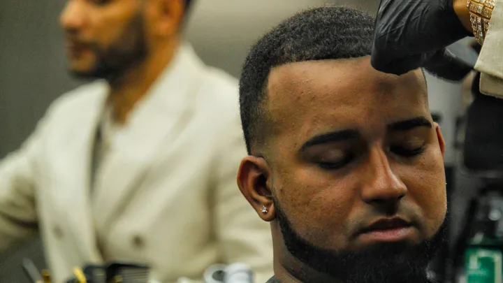 Barber shaping a clean fade haircut